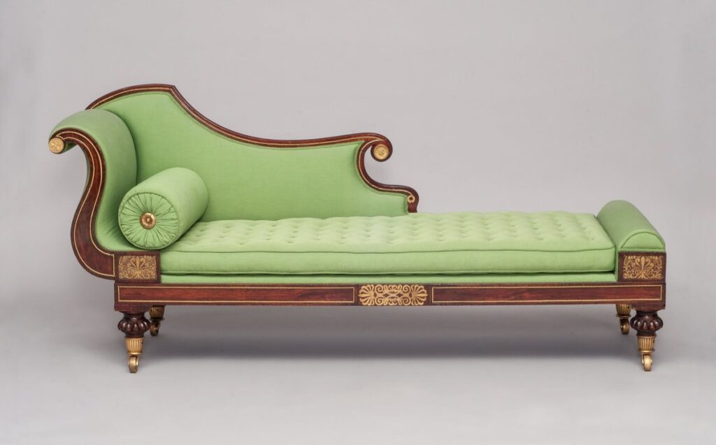 Green couch with curved back and rounded pillow.